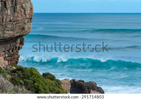 Breaking wave at Wilyabrup cliff, Western Australia, with big sets rolling in behind