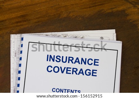 insurance coverage abstract with blueprints and coffee.