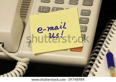 Voip Phone with email us message written on yellow note.
