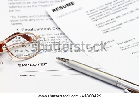 close up of resume form with employment contract ready to sign.