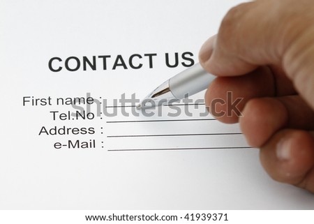 Hand holding a pen  isolated over white writing contact us!