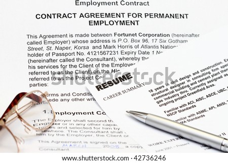 close up of resume form on white with employment contract. Note: all information are fiction.