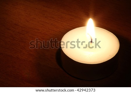 One Burning candle in the dark- many uses in religion or faith.