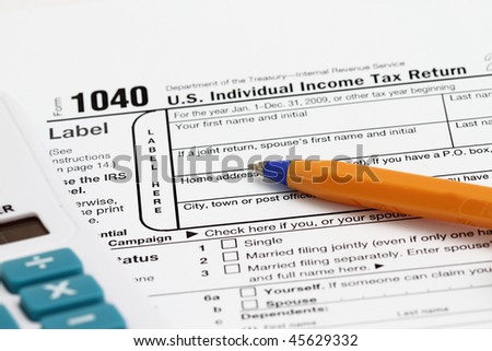 completing a 1040 tax form with calculator.