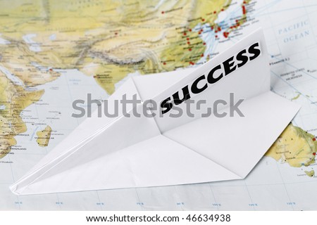 Paper Plane with Success in a world map.