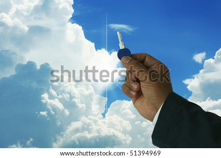 A photo of a businessman holding a key with nice blue sky and sunrays- many uses in the real state industry.
