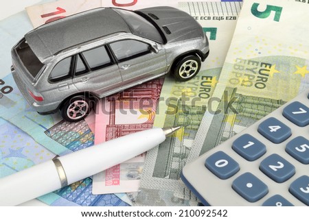 A luxury car on Euro cash, with a calculator and pen to symbolize car finance.