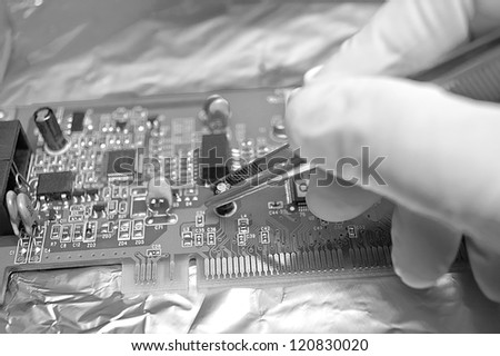 Electronic technician repairing computer hardware in the lab