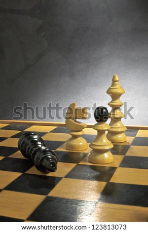 Chess game comes to an end over a grunge background. The king is checkmated.
