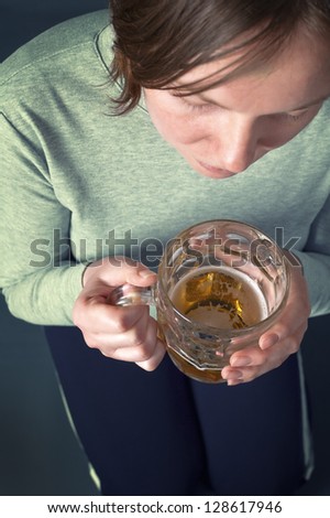 Portrait of an adult woman drinking beer. Depression concept.