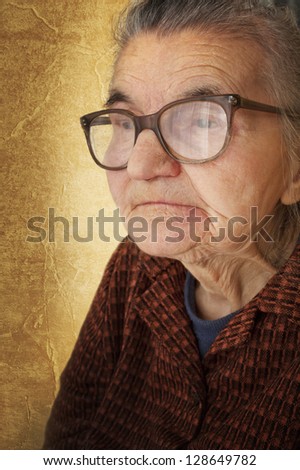 Portrait of an old woman on a vintage background. Dreaming the past