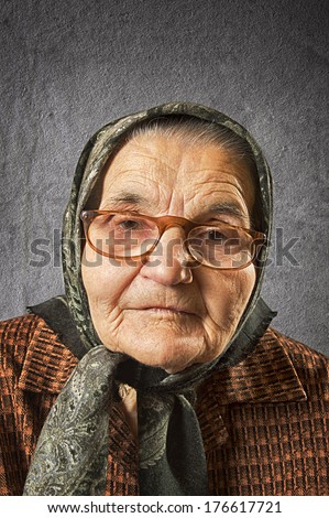 Portrait of an old woman on a vintage background, dreaming the past. Soft focus.