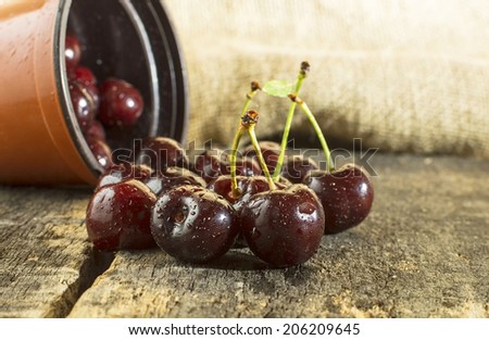 Cherries on wooden table with water drops.
