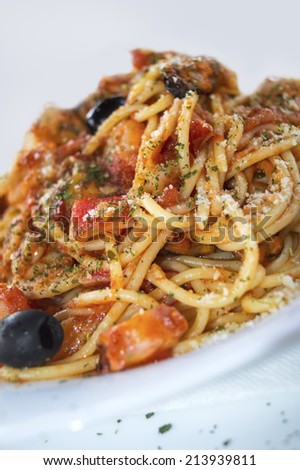 Spaghetti with seafood on white dish.