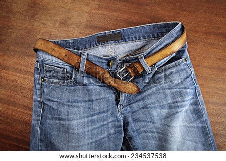 Detail of nice blue jeans with leather belt.
