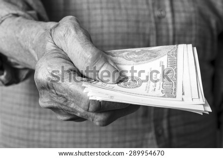 Money dollars in elderly hand. Selective focus.
