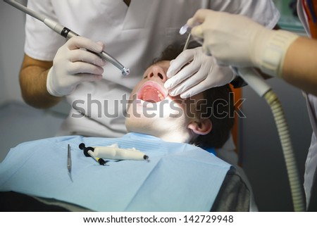 Dentist treats teeth to the patient in a private clinic