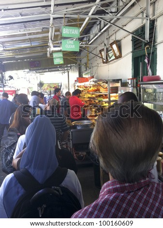 PENANG, MALAYSIA-APRIL 13:A row of customer queue to buy \'nasi kandar\' or \'kandar rice\' in Penang, Malaysia on April 13, 2012. Nasi kandar is a popular spicy dish originating from Penang Indian Muslim