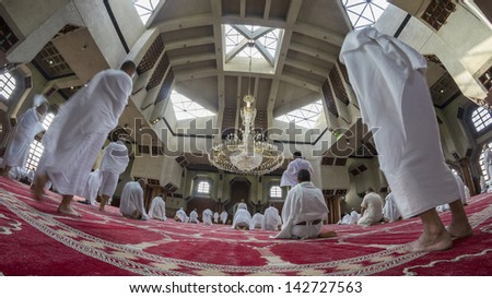 MECCA - FEB 25 : Muslim pilgrims in \'ihram\' clothes pray at Tanaem mosque on Feb 25, 2012 in Mecca. \'Ihram\' clothes consist of two unhemmed white clothes intended to make everyone appear the same.