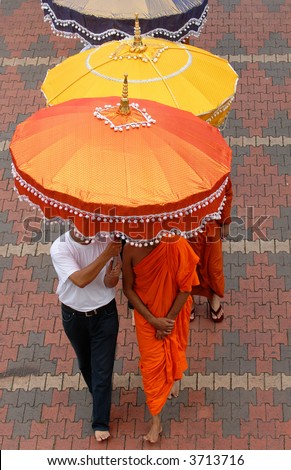 Buddhist monks under umbrella