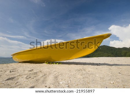 Yellow colored kayak on an empty beach.