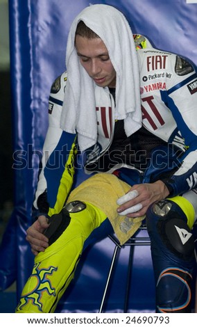 SEPANG, MALAYSIA - FEBRUARY 7: MotoGP world champion Valentino Rossi of Italy adjusts his knee pad with his two fingers in bandages at MotoGP testing at Sepang, near Kuala Lumpur February 7, 2009.
