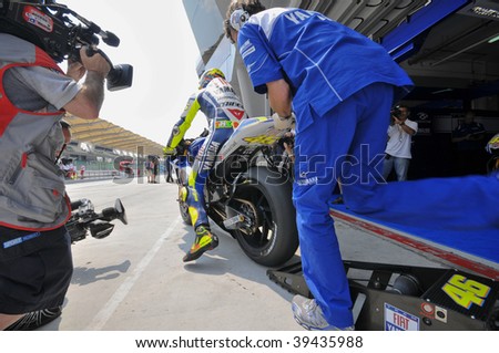 SEPANG, MALAYSIA - OCT 23 : A mechanic pushes Italian Valentino Rossi\'s bike during the first testing session at Shell Advance Malaysian Motorcycle Grand Prix held October 23, 2009 in Sepang, Malaysia.