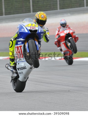 SEPANG, MALAYSIA - OCT 23 : Italian Valentino Rossi (L) of Fiat Yamaha Team does a wheelie at Shell Advance Malaysian Motorcycle Grand Prix October 23, 2009 in Sepang. Nicky Hayden in the background.