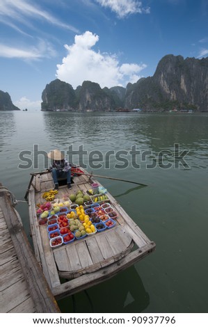 Unidentified female fruit seller sells various types of fruits on boat in Halong Bay, Vietnam