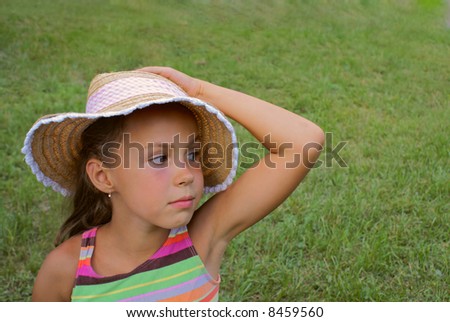 stock photo Preteen girl in strow hat on grass background