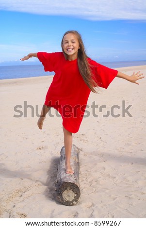 stock photo Cheerful preteen girl exercising on a beach
