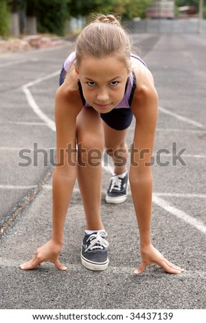 stock photo Preteen girl starting to run on track