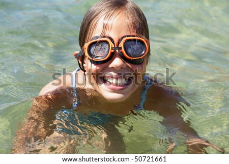 stock photo Happy preteen girl swiming in sea water