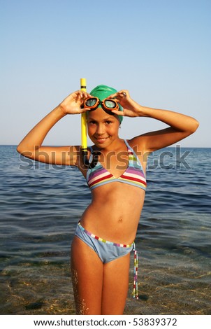 Preteen girl in diving outfit enjoying sun-bath on sea beach