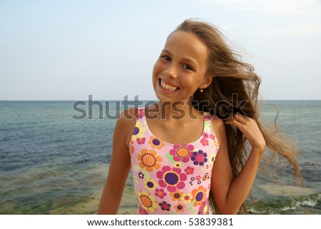 stock photo Cheerful preteen girl enjoying sunbath on sea beach