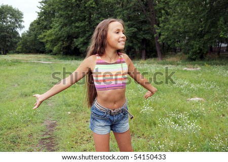 stock photo Portrait of cheerful running preteen girl outdoors in park