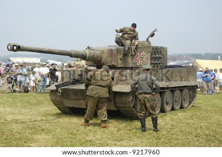 German World War 11 Tiger Tank and reenactors portraying German Troops at a World War 11 reenactment.