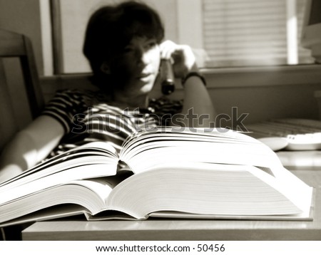 Girl is doing her homework and talking on the phone