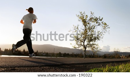 woman jogging along a river in the morning