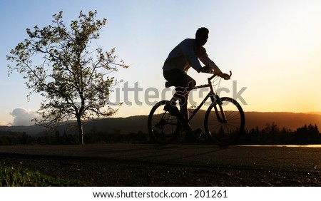 Man riding his bike at sunset
