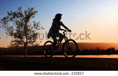 Woman riding her bike at sunset