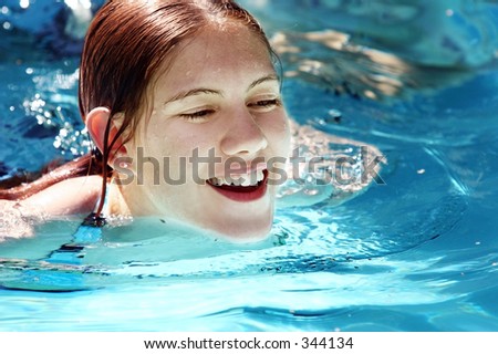 stock photo Happy girl swimming in a pool