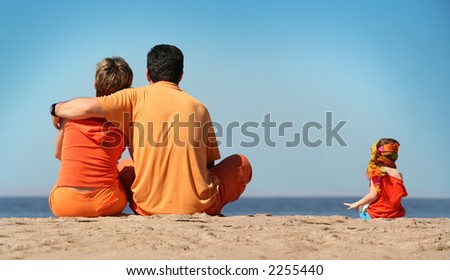 Family in orange clothes on the beach