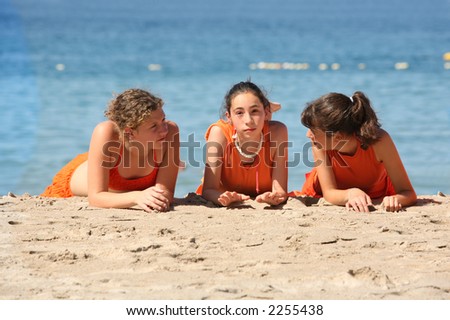 Three girls in orange clothes on the beach
