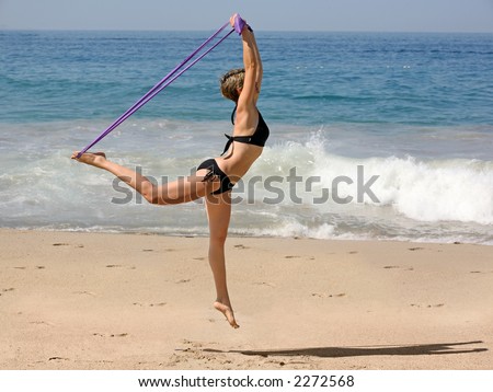 Woman Exercising on the beach with a rubber band