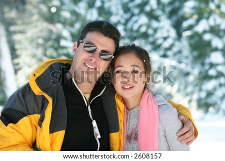 Father and daughter standing in a winter forest