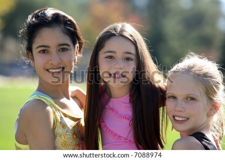 Three pretty girls of different ages and races smiling