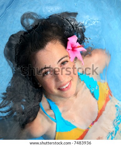 stock photo Pretty teen girl with a fower in a pool