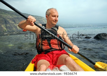 Mature man kayaking in the ocean on Big Island, Hawaii