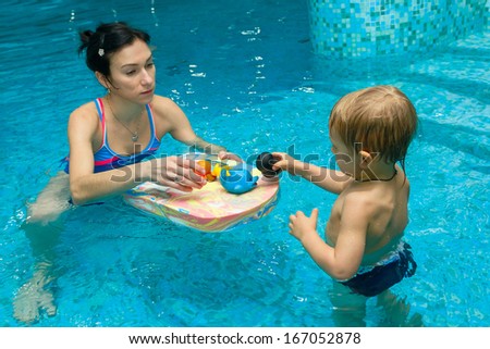 Mom teaches baby to swim in water